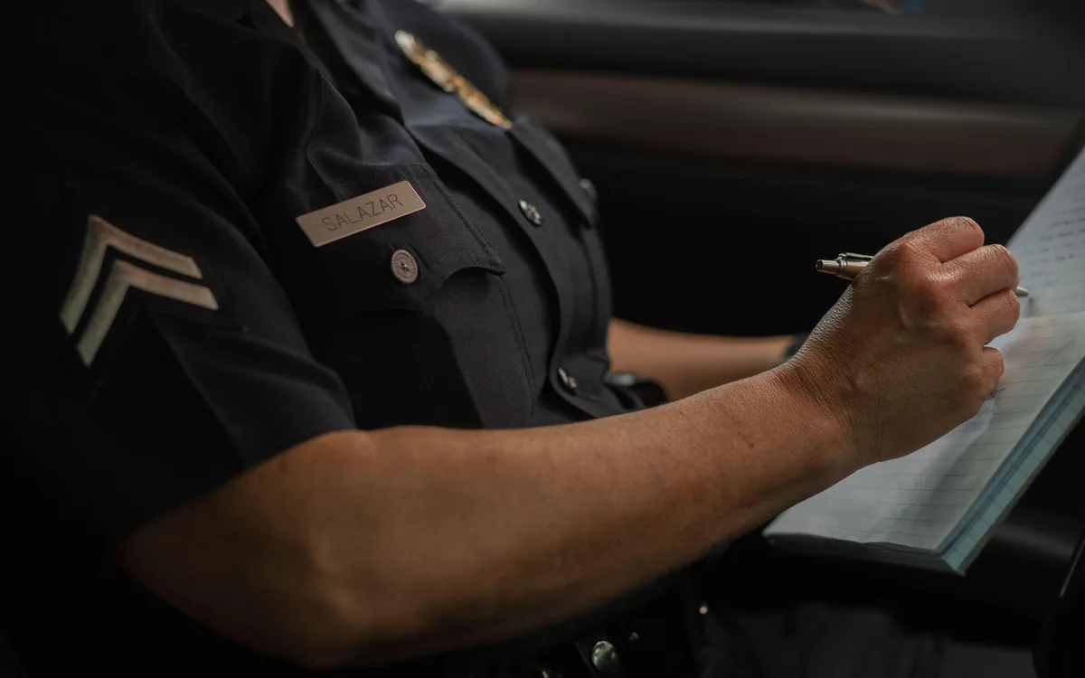 A California law enforcement officer completing a traffic collision report at the roadside