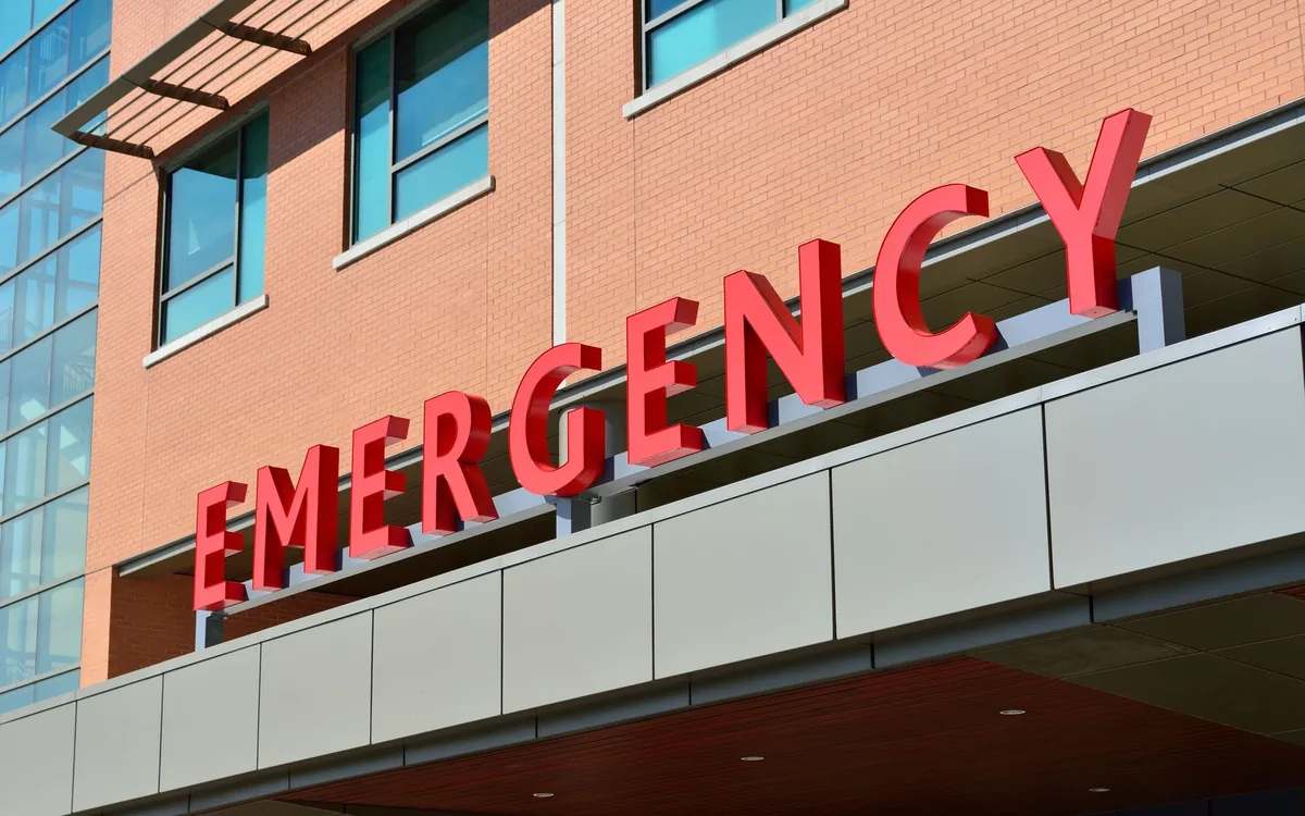 The illuminated EMERGENCY sign outside a hospital emergency department