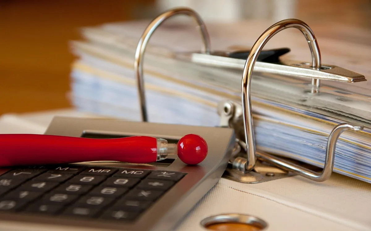 A calculator resting on case files and paperwork